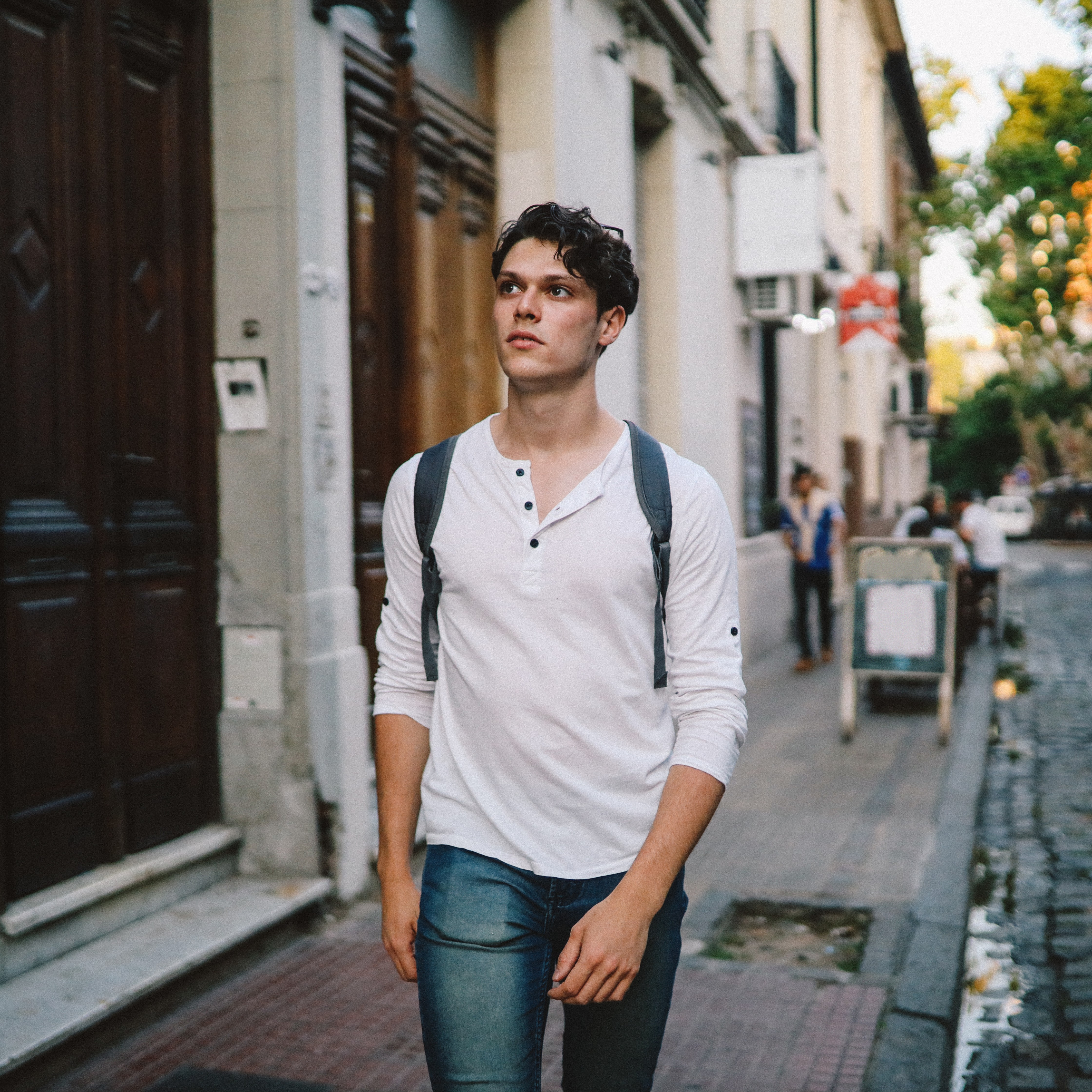 Man in a henley walking down the street