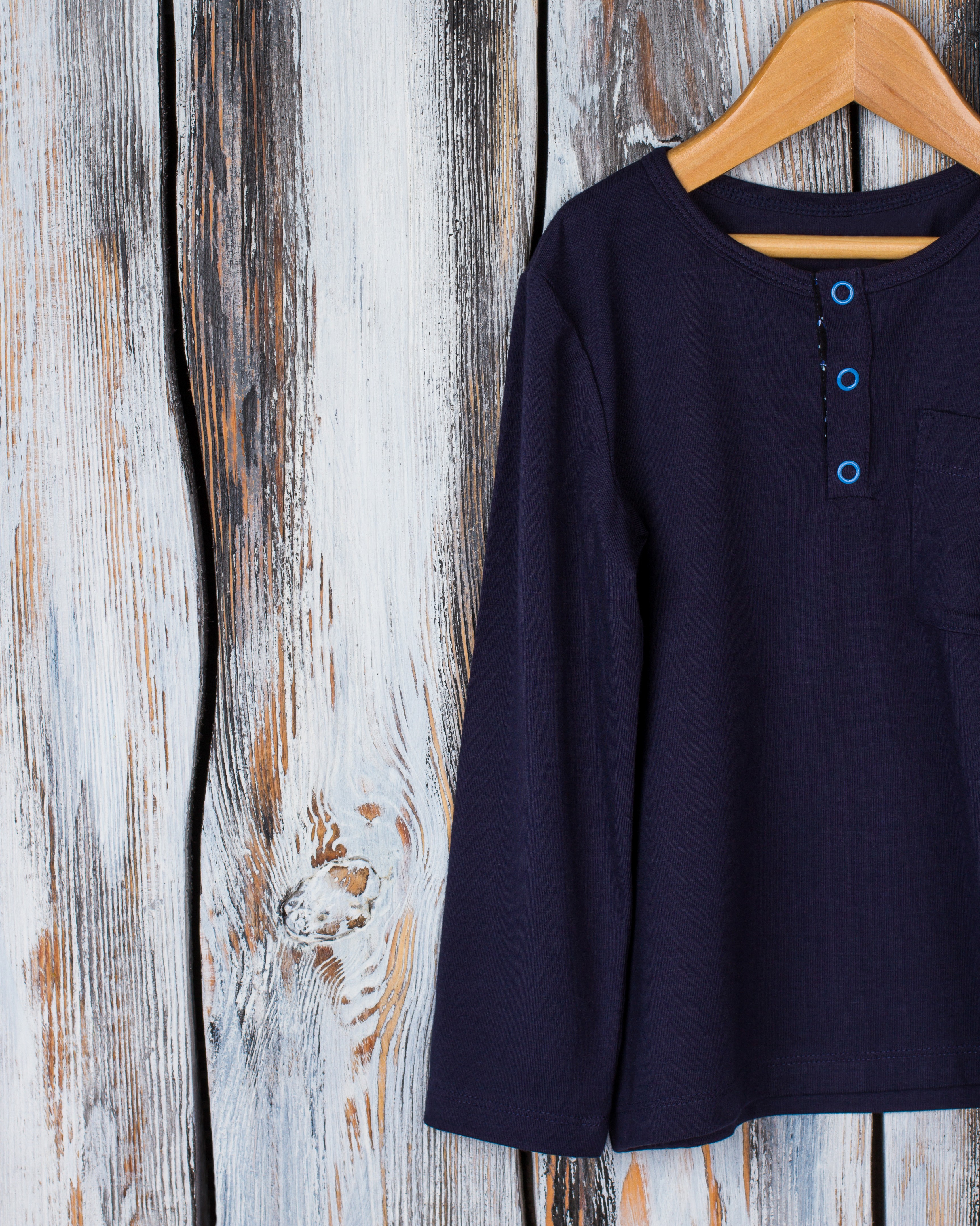 Henley shirt on a hanger in a rustic wardrobe
